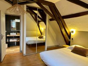 Cette chambre comprend 2 lits et un miroir. dans l'établissement Château de la Borde à Ussel, à Ussel