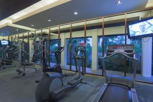 a gym with several tread machines and a television at Veranda Pool Suite in Cha Am