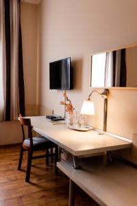 a room with a desk with a lamp and a mirror at Hotel Nevada in Łagów