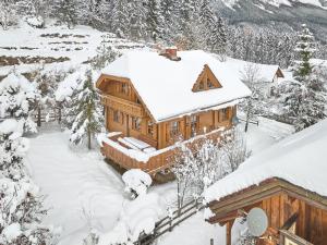 a log cabin in the snow with snow at Alpenglück Chalet Schladming - Dachstein by AA Holiday Homes in Sankt Martin am Grimming
