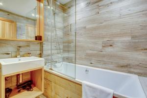 a bathroom with a white tub and a sink at Auberge RDC in Morzine