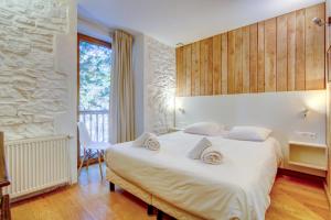 a bedroom with a large bed with a stone wall at Auberge RDC in Morzine