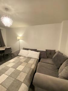 uma sala de estar com um sofá e uma mesa em Cosy Apartment Near Bluewater With Private Parking em Kent