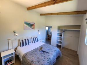 a bedroom with a bed with a blue comforter at Caracal Cottage in Plettenberg Bay