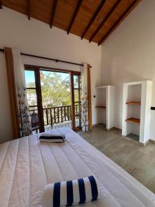 a bedroom with a large bed and a balcony at The Point Mirissa in Mirissa