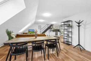 cocina y comedor con mesa y sillas en Sali Homes - Residenz zum Breitenauer See, en Obersulm