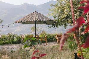 a picnic table and an umbrella with mountains in the background at Zili Homestay in Sa Pa