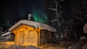 a cabin in the snow with the aurora in the sky at Lapland Snow Moose in Vittangi Kapell