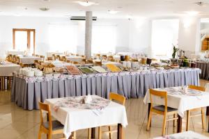 uma sala de jantar com mesas e toalhas de mesa brancas em Hotel Nevada em Łagów