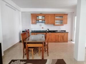 a kitchen with wooden cabinets and a table and chairs at MIA SEN VỌNG HOTEL in Hanoi