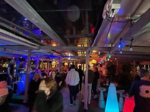 a group of people walking around a bar at night at P-Hotels Brattøra in Trondheim