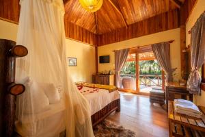 a bedroom with a bed with a mosquito net at Chez Carole Beach Resort Phu Quoc in Phu Quoc