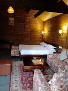 um quarto de hotel com duas camas e um sofá em The Heritage Club - Tripura Castle em Shillong