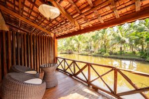 フーコックにあるChez Carole Beach Resort Phu Quocの川の景色を望むバルコニー(椅子付)