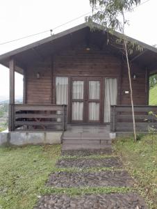uma cabana de madeira com um alpendre e uma porta em The Heritage Club - Tripura Castle em Shillong