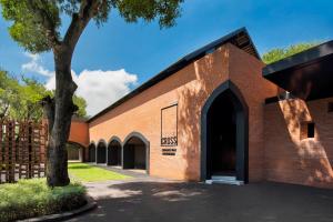 Una iglesia de ladrillo con un árbol delante de él. en Cross Chiang Mai Riverside, en Chiang Mai