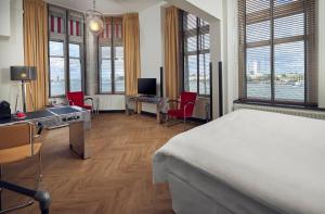 una camera con letto, scrivania e sedie di Hotel New York a Rotterdam
