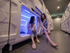 dos chicas sentadas en un tren subterráneo en Digital Airport Hotel, en Tangerang