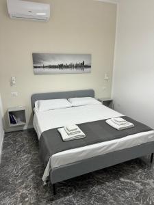 a bedroom with a bed with two towels on it at Living Room Orlando in Corigliano Calabro +23 photos
