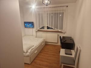 Habitación pequeña con cama y escritorio. en Noclegi Budomas Budget FreeParking, Free Netflix, Free Youtube Premium, en Wroclaw