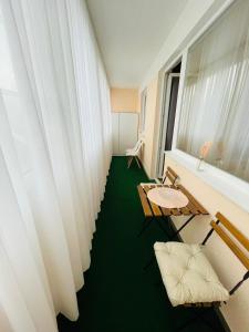 a room with white curtains and a green floor at Magnifique Appartment in Linz