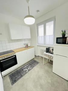 cocina con armarios blancos y fogones en Magnifique Appartment, en Linz