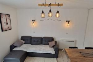 uma sala de estar com um sofá, uma mesa e luzes em Appartement cosy rue Pasteur em Briançon
