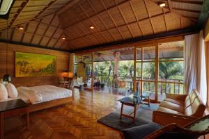 a bedroom with a bed and a living room at Sunset Ubud Estate with Ricefield views - RUSTERS Villa Estate in Ubud