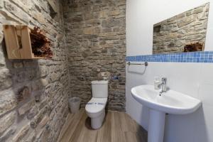 een badkamer met een wit toilet en een wastafel bij Casa rural MAZA especial grupos in Biescas