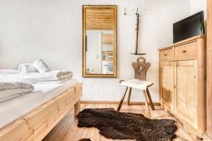 une chambre avec un lit, un miroir et une chaise dans l'établissement Ferienwohnung Zweisamkeit, à Brand