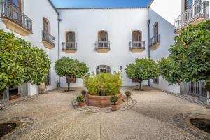 un patio con árboles frente a un edificio en Palacio Marqués Vega Armijo & Parking incluido, en Córdoba