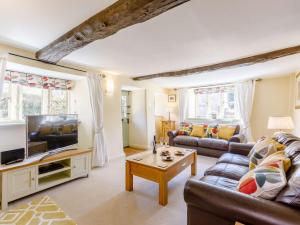 a living room with a couch and a tv at 3 Bed in Bourton-on-the-Water PTREE in Bourton on the Water