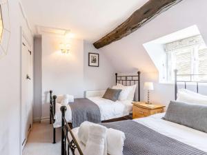 a bedroom with two beds and a window at 3 Bed in Bourton-on-the-Water PTREE in Bourton on the Water