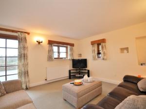 a living room with a couch and a tv at 3 Bed in Wembury COMBV in Wembury