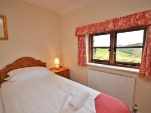 a bedroom with a bed and a window at 3 Bed in Wembury COMBV in Wembury