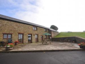 a brick building with a patio with a picnic table at 3 Bed in Wembury COMBV in Wembury