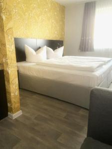 a bedroom with a large bed with white sheets at Hotel 22 in Dessau