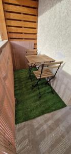 a picnic table and bench sitting on a patch of grass at Appartement cosy rue Pasteur in Briançon