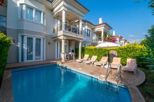 eine Villa mit einem Pool vor einem Haus in der Unterkunft Sunset Beach Club Aqualettings Oyster 5 in Fethiye
