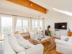 a living room with white couches and a table at 3 Bed in Pwllheli 89023 in Pwllheli
