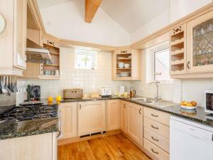 a kitchen with wooden cabinets and a stove top oven at 3 Bed in Pwllheli 89023 in Pwllheli