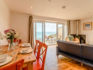 a dining room with a table and a couch at 2 Bed in Tresaith 89315 in Penbryn