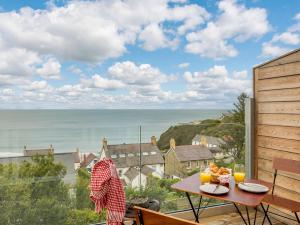 a table on a balcony with a view of the ocean at 2 Bed in Tresaith 89315 in Penbryn