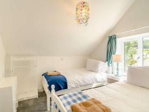 1 dormitorio con 2 camas y lámpara de araña en 2 Bed in Tresaith 89315 en Penbryn