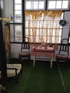 um quarto com uma mesa e duas cadeiras e uma janela em Royal Pine em Shillong