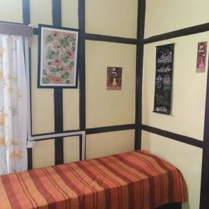 um quarto com uma cama e quadros na parede em Royal Pine em Shillong