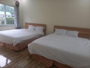 two beds sitting next to each other in a bedroom at Trang An Pristine View homestay in Ninh Binh