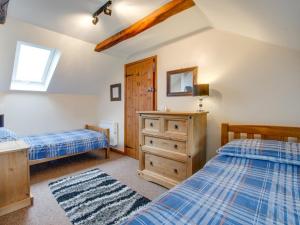 2 Bed in South Molton 88992 في Bishops Nympton: غرفة نوم بسريرين وخزانة خشبية