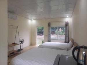 a room with two beds and a window at Trang An Pristine View homestay in Ninh Binh