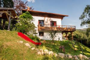 a house with a red umbrella in front of it at Le refuge du peintre in Gérardmer